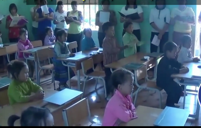 Các em lần lượt đứng dậy vỗ tay theo nhịp đánh vần lần lượt cho đến hết lớp. (Ảnh cắt từ clip)