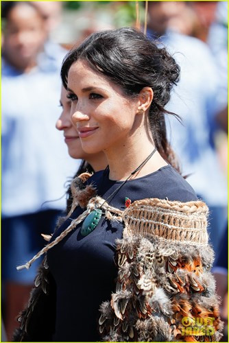 Nữ công tước xứ Sussex đang mang bầu ở tháng thứ 4. Cô mặc bộ đầm xanh navy thanh lịch của Stella McCartney. Bên ngoài khoác áo choàng lông vũ.