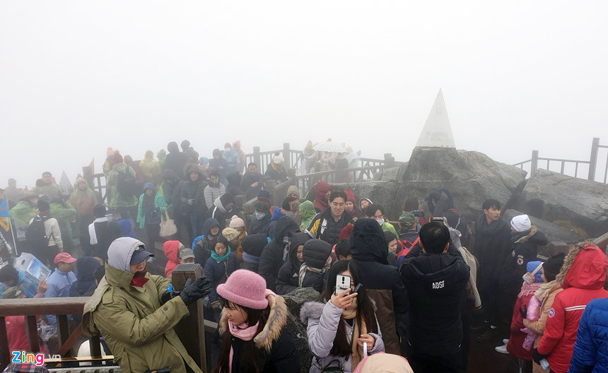 Hàng trăm du khách chen chúc chụp ảnh trước tháp 3.143 m trên đỉnh Fansipan trưa 1/1.