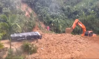 Hàng tấn đất đổ vùi lên chiếc xe tải, tài xế may mắn thoát chết trong gang tấc. Ảnh V. Phức