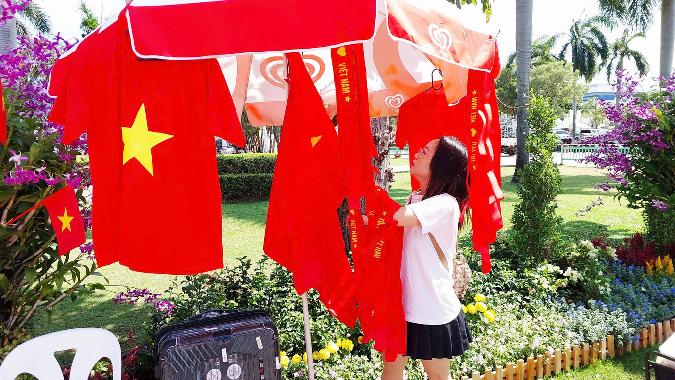 អ្នកស្រី ង្វៀន ធីភឿង ឈរក្បែរទង់ជាតិ និងអាវពណ៌ក្រហមរបស់គាត់ដែលមានផ្កាយពណ៌លឿង។ រូបថត៖ ថាញ់ហៃ z7328614943050-fffb86642c85f9039906fdcf3b30c25a.jpg