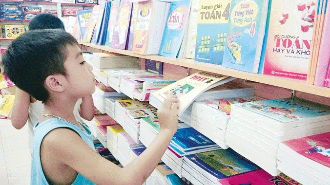 Một học sinh đang tìm chọn sách giáo khoa cho năm học mới. Ảnh: Ngọc Châu