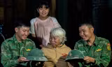 Hai người lính trẻ chụp ảnh lưu niệm, chia tay gia đình cụ Ngô Thị Lỡ với những chiếc mũ cối dính xi măng, có chiếc đứt dây Ảnh: Lê Văn Chương 