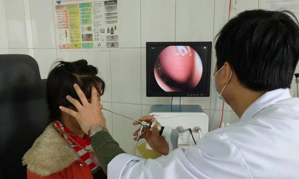 Bác sĩ đang gắp con vắt dài 5 cm trong mũi em Hồ Thị Bông. Ảnh: P.V. Tú.