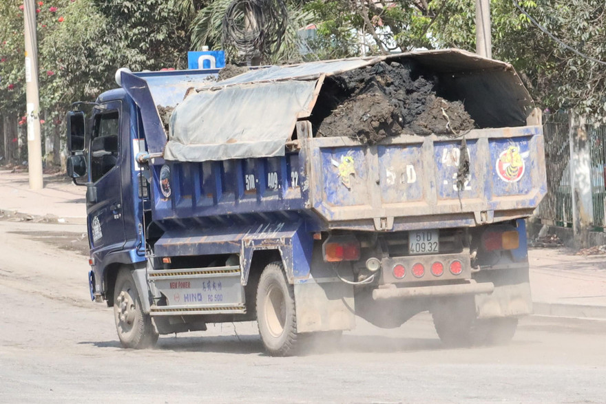 Xe tải chở bùn 'bầy hầy' chạy ầm ầm trên đường.