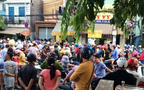 Hàng trăm người dân tập trung theo dõi lực lượng chức năng khám nghiệm hiện trường. Ảnh: A.X