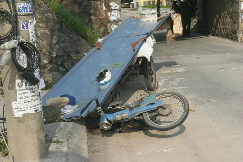 Chiếc xe máy kéo theo xe thô sơ chở tôn bị lật nhào.