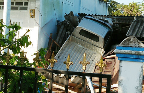 Xe tải 'bay' qua ngọn cây, rơi xuống nóc nhà