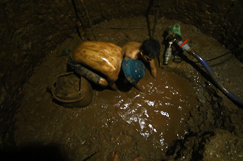 Hơn và Hiên cặm cụi nơi đáy giếng tối với nỗi hiểm nguy cướp đi sinh mạng bất cứ lúc nào. Ảnh: Nguyễn Đông.