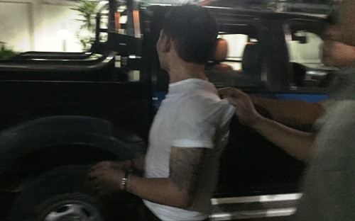 Nam thanh niên bị cảnh sát khống chế sau khi mở cửa. Ảnh: A.X