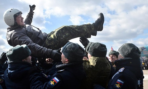 Một phi công Nga trở về từ Syria được các sĩ quan quân đội tung hô như người hùng. Ảnh: Tass