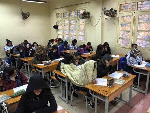 Hình ảnh ngộ nghĩnh một nhóm bạn chia sẻ với nhau một chiếc chăn ấm trong lớp học ngày giá rét.