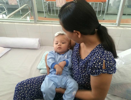 Bé Minh Phát trong vòng tay mẹ ngày xuất viện. 