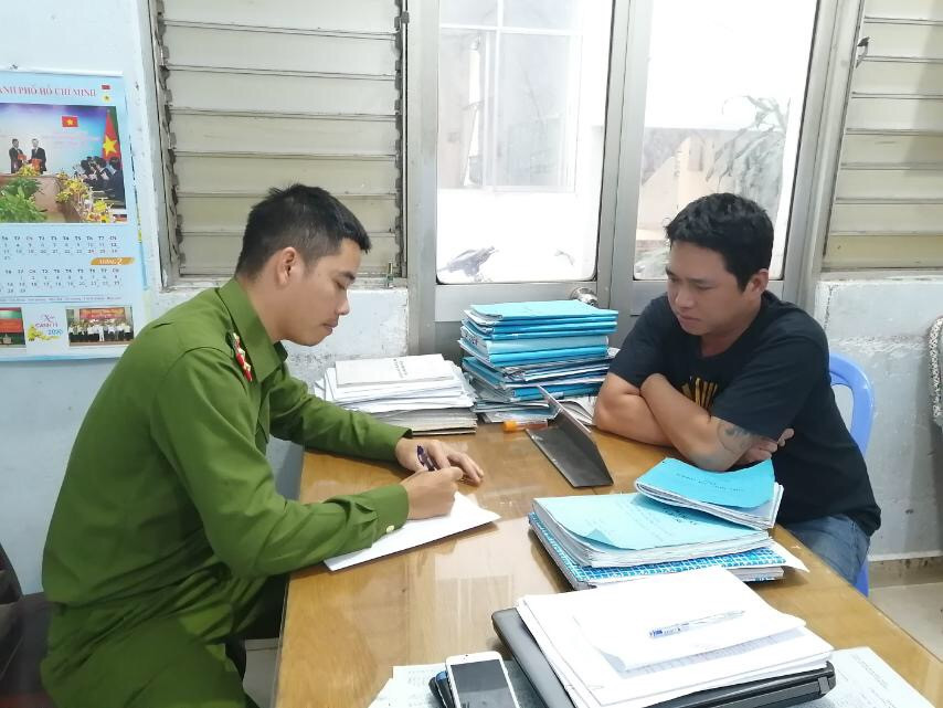 Cảnh sát lấy lời khai một trong số 10 đối tượng bị bắt. Ảnh CA