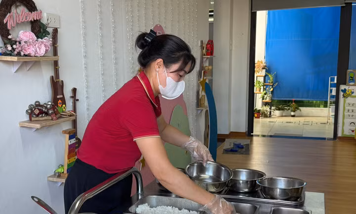 Giáo viên Trường mầm non Họa Mi chia cơm cho trẻ ăn bữa trưa. 
