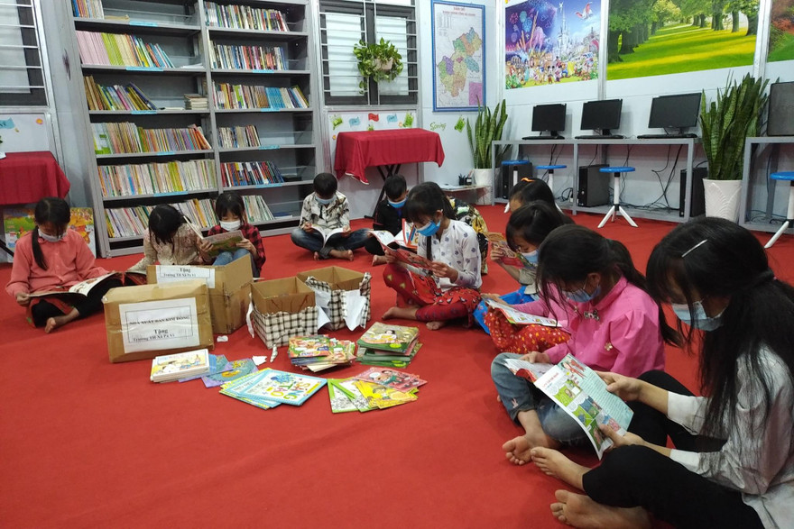Học sinh Trường Tiểu học Pả Vi đọc sách báo được trao tặng trong khi trường bị phong tỏa