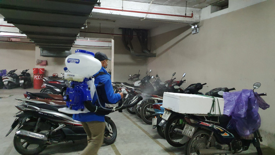 Công nhân phun thuốc khử khuẩn tại khu vực để xe