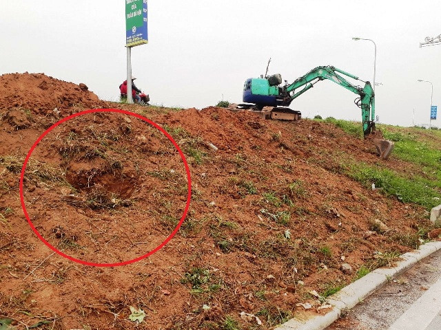 Hình ảnh máy xúc múc các hố để chôn lấp rác, gạch đá vào thân đê