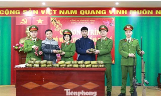 Người dân giao nộp vũ khí nhận quà Tết tại Công an phường Chũ (tỉnh Bắc Ninh).