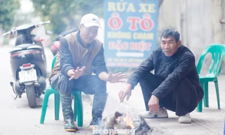 Ông Đỗ Văn Thủy (bên trái) nhóm lửa sưởi ấm. Ảnh: Nguyễn Thắng