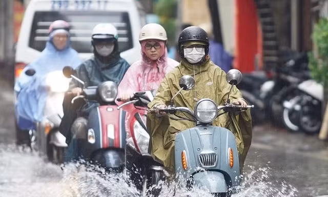 Người dân Hà Nội di chuyển dưới trời mưa và thời tiết mát