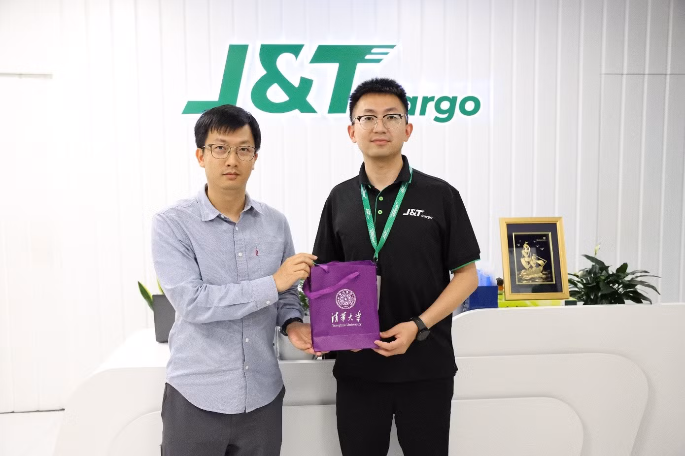 Tiến sĩ Quản Hạo (trái) đại diện ĐH Thanh Hoa trao quà lưu niệm cho ông Vương Hạo – Giám đốc Trung tâm Nhân sự J&amp;T Cargo. Ảnh: J&amp;T Cargo