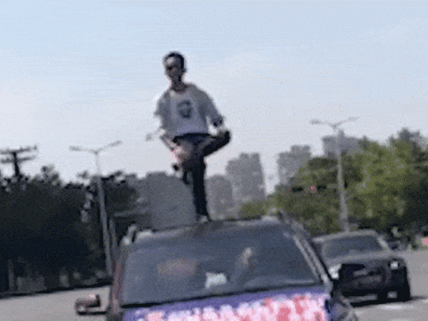 Liều lĩnh đứng thăng bằng bằng một chân trên nóc ô tô đang di chuyển