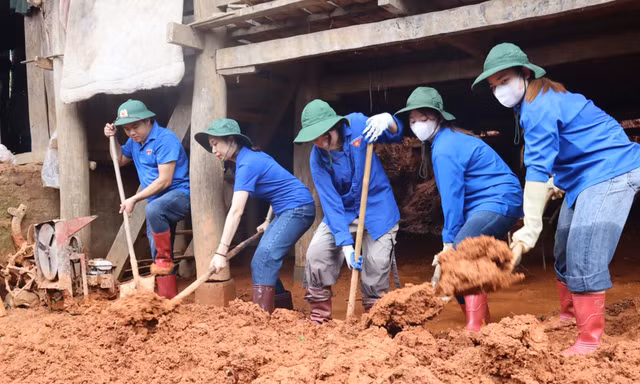 Ðoàn viên, thanh niên tỉnh Sơn La giúp người dân dọn dẹp nhà sau lũ. Ảnh: Viết Hà