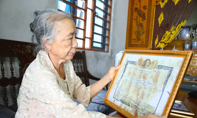 Bà Nguyễn Thị Ngọ bên Tấm bằng Tổ quốc ghi công liệt sĩ Nguyễn Văn Đinh
