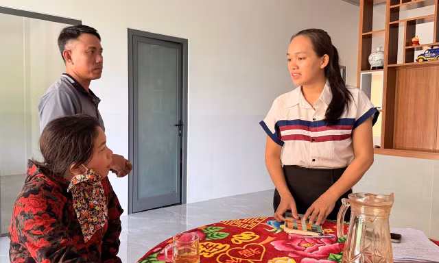Trưởng thôn Nguyễn Thị Ly (bìa phải) trao đổi, hướng dẫn người dân làm các thủ tục hành chính