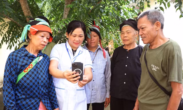 Cán bộ y tế xã biên giới Thanh Thủy (Tuyên Quang) hướng dẫn người dân sử dụng điện thoại thông minh, tiếp cận dịch vụ số Ảnh: Đức Thọ