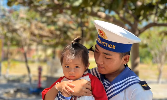 Chiến sĩ trẻ bế em bé của người dân sinh sống trên đảo Đá Tây A 