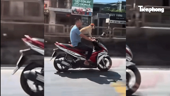 Người đầu trần chạy xe máy chở chó đội mũ bảo hiểm trên quốc lộ gây xôn xao