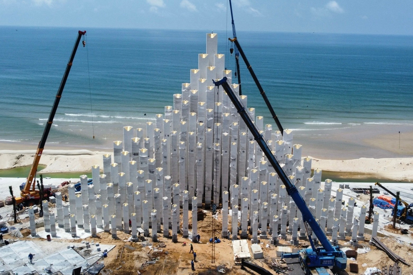 Đơn vị thi công tiến hành bổ sung một số chi tiết trang trí chẳng hạn lắp hệ thống đèn, ốp gạch gốm mosaic trên đỉnh các cột... Theo Ban Quản lý dự án đầu tư xây dựng khu vực Vũng Tàu, bản thiết kế tháp Tam Thắng được lựa chọn sau 3 lần từ một cuộc thi do UBND Vũng Tàu cũ tổ chức thi tuyển từ năm 2024. Ý tưởng đạt giải nhất ở lần 3 được thạc sĩ, kiến trúc sư Oliviero Godi thuộc hội kiến trúc sư Milan, Italy, cùng cộng sự lấy cảm hứng từ ba ngôi làng Tam Thắng (Thắng Nhất, Thắng Nhì và Thắng Tam) thời vua Gia Long (1802-1820). Ảnh: Hoàng Nhân.