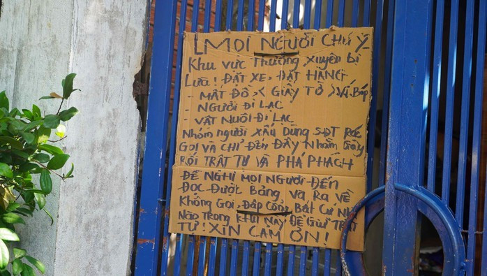 Một trong những biển cảnh báo được gắn ở cổng nhà dân trong hẻm