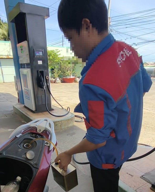Nhân viên cây xăng rút xăng từ xe máy ra, sau khi không chấp nhận chuyển khoản. Ảnh: MXH