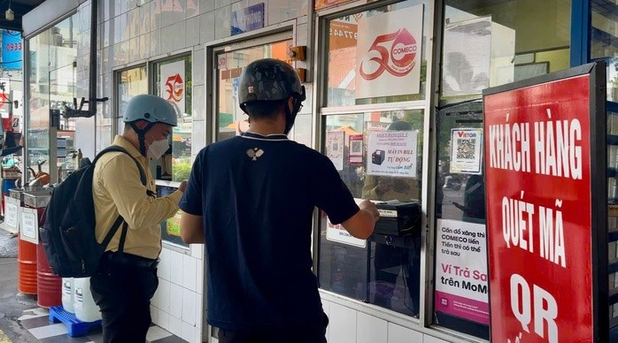 Nhiều người dân sử dụng hình thức thanh toán chuyển khoản để đổ xăng tại cây xăng PVOIL COMECO Cửa hàng Xăng dầu Số 1 (góc Lý Thái Tổ - Lê Hồng Phong, phường Vườn Lài, TPHCM)