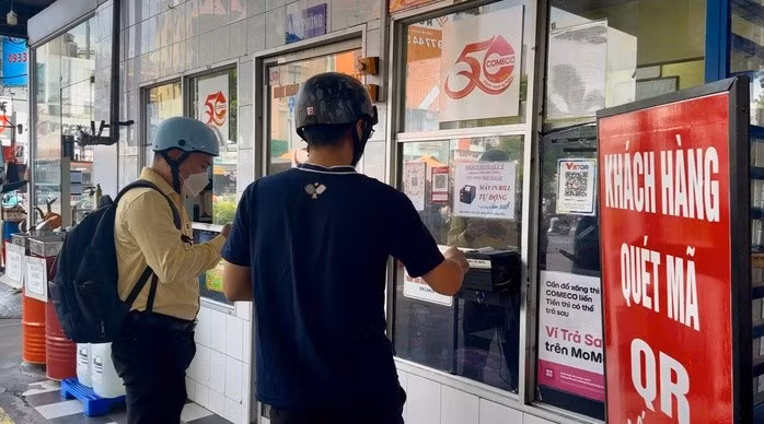 Nhiều người dân sử dụng hình thức thanh toán chuyển khoản để đổ xăng tại cây xăng PVOIL COMECO Cửa hàng Xăng dầu Số 1 (góc Lý Thái Tổ - Lê Hồng Phong, phường Vườn Lài, TPHCM)