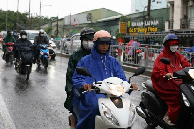 Người dân tham gia giao thông vất vả, di chuyển chậm trong cơn mưa