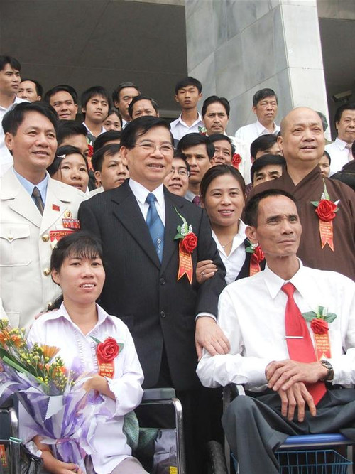 Chủ tịch nước Nguyễn Minh Triết tặng hoa biểu dương người tàn tật, trẻ mồ côi và người bảo trợ tiêu biểu. Ảnh: Minh Tuấn