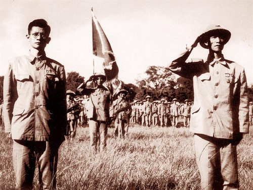 Thiếu tướng Vương Thừa Vũ và bác sĩ Trần Duy Hưng cùng toàn quân đang nghiêm trang làm lễ chào cờ . Ảnh: Phan Xuân Thúy