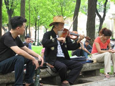 Nghệ sĩ “đường phố” Tạ Trí Hải chơi đàn tại Công viên 30-4. Ảnh: PV