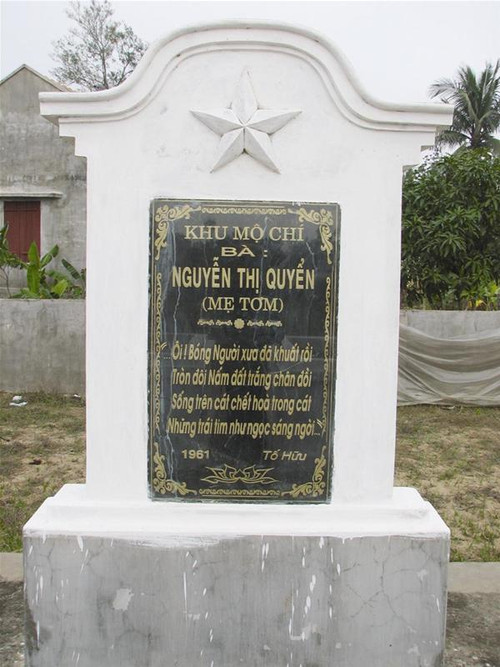 Mộ của Mẹ Tơm - phía sau là ngôi nhà mái bằng được con cháu của Mẹ xây dựng ở thôn Đông Thành vừa được công nhận là di tích lịch sử cấp tỉnh - Ảnh: Hoàng Lam