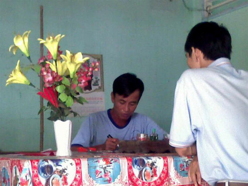 Phóng viên đang được thầy Trưng (áo xanh bên trái) ghi bùa để chữa bệnh