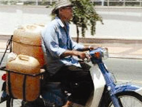 Một người buôn lậu xăng dầu ở Campuchia.