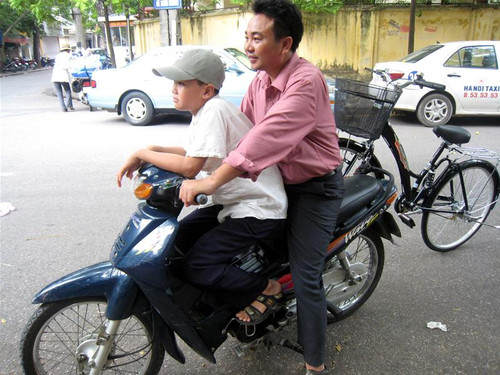 Hai bố con Nguyễn Minh Thắng và chiếc xe đạp vừa được trao tặng. Ảnh: XM.