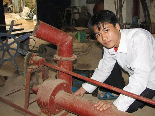 Vũ Thái Hiển đang lắp đặt mô hình máy bơm ba chức năng tại xưởng của gia đình. Ảnh: Hoàng Lam