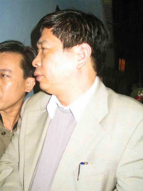 Bùi Tiến Dũng bị áp giải ra xe ô tô sau khi điều tra viên hoàn tất việc khám nhà. Ảnh: Công Hùng