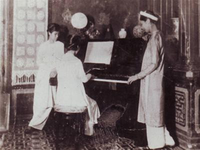 Nguyễn Thị Vân đang chơi đàn, đứng cạnh hai bên là Nguyễn Thị Loan và Nguyễn Thị Nội.