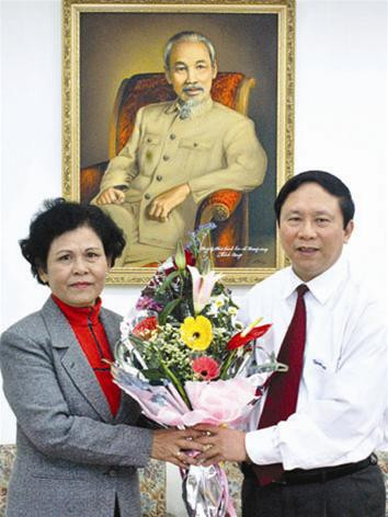 Tổng biên tập báo Tiền Phong Dương Xuân Nam tặng hoa tác giả Phạm Thị Xuân Khải sau 20 năm gặp lại. Ảnh: Phạm Yên